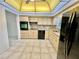 Bright kitchen with light wood cabinets, black appliances, granite countertops, skylight, and tile flooring at 2341 Haitian Dr # 49, Clearwater, FL 33763