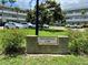 Brick monument sign with the address 'Baghdad 2341' against a background of cars and the condo complex at 2341 Haitian Dr # 49, Clearwater, FL 33763