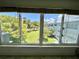Close-up of windows showcasing a pleasant, grassy courtyard with mature trees at 2341 Haitian Dr # 49, Clearwater, FL 33763