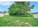 Serene backyard features mature trees offering shade, enclosed by a white privacy fence at 247 Winthrop Dr, Spring Hill, FL 34609