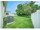 Spacious backyard with a well maintained lawn, surrounded by a white fence for privacy at 247 Winthrop Dr, Spring Hill, FL 34609