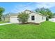 The house features an expansive green lawn, garden beds, and a mature tree at 247 Winthrop Dr, Spring Hill, FL 34609