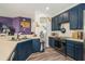 Open kitchen with stainless steel appliances, blue cabinets, and wood floors at 247 Winthrop Dr, Spring Hill, FL 34609