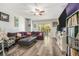 Living room with a large sectional couch, wood floors, and access to the patio at 247 Winthrop Dr, Spring Hill, FL 34609