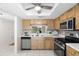 Bright kitchen with stainless steel appliances, light cabinetry, and a pass-through to the living area at 2557 Laurelwood Dr # 10D, Clearwater, FL 33763