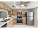 Well-lit kitchen featuring stainless steel appliances, light wood cabinets, and tile backsplash at 2557 Laurelwood Dr # 10D, Clearwater, FL 33763