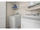 This laundry room features a full-size washer and dryer and metal shelving at 2557 Laurelwood Dr # 10D, Clearwater, FL 33763