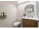 This powder room has updated vanity and round mirror with neutral accents at 2557 Laurelwood Dr # 10D, Clearwater, FL 33763