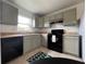 A contemporary kitchen with light-grey cabinetry, black appliances, and bright natural light at 2850 Somerset Park Dr # 203, Tampa, FL 33613