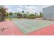 A community tennis court bordered by lush trees and palms, offering recreational opportunities for residents at 2850 Somerset Park Dr # 203, Tampa, FL 33613