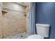Tiled shower featuring neutral stones, shower head, built-in shelves, and a toilet at 2901 W 26Th St # 301, Bradenton, FL 34205