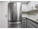 Modern kitchen featuring stainless steel refrigerator, granite countertops, and white upper cabinets at 2901 W 26Th St # 301, Bradenton, FL 34205