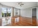 Bright living room with hardwood floors, neutral walls, ceiling fan, and sliding glass door to a balcony at 2901 W 26Th St # 301, Bradenton, FL 34205