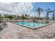 Outdoor pool area with brick-paved deck, lounge chairs, tables, and lush landscaping at 2901 W 26Th St # 301, Bradenton, FL 34205