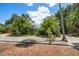 Charming home with lush tropical landscaping, a mailbox, and a brick-paved street at 301 Cevera Dr, Dunedin, FL 34698