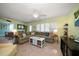 Bright living room featuring a sectional sofa, terrazzo floors, and an inviting coastal aesthetic at 301 Cevera Dr, Dunedin, FL 34698