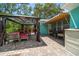 Outdoor patio features an outdoor dining area plus a cabana with bench seating at 301 Cevera Dr, Dunedin, FL 34698