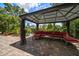 Outdoor patio features a cabana with bench seating and tropical foliage at 301 Cevera Dr, Dunedin, FL 34698