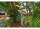 Colorful direction signpost amidst lush foliage, indicating nearby attractions such as beaches at 301 Cevera Dr, Dunedin, FL 34698