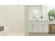 Bright and modern bathroom with white tile shower and double sink vanity at 31616 Cardinal Yard Dr, San Antonio, FL 33576