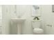 Neat bathroom featuring a white pedestal sink, toilet and large oval mirror at 31616 Cardinal Yard Dr, San Antonio, FL 33576
