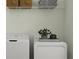 Neat laundry area featuring white washer and dryer, along with shelving and storage space at 31616 Cardinal Yard Dr, San Antonio, FL 33576