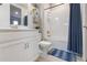 Bathroom with white fixtures, vanity, toilet, and shower-tub combo with blue accents at 3312 Francoa Dr, Odessa, FL 33556
