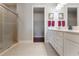Bright bathroom featuring a glass-enclosed shower and a dual sink vanity with white cabinets at 3312 Francoa Dr, Odessa, FL 33556