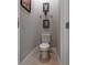 Small bathroom with a white toilet and decorative wall art in a neutral color scheme at 3312 Francoa Dr, Odessa, FL 33556