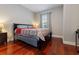 Bedroom featuring a bed with decorative bedding, hardwood floors, and natural light from a window at 3312 Francoa Dr, Odessa, FL 33556