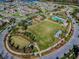 Aerial shot of neighborhood with a park featuring a large green space, playground, and pool at 3312 Francoa Dr, Odessa, FL 33556