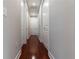 Hallway with glossy wood floors, white walls, and multiple doors and closets at 3312 Francoa Dr, Odessa, FL 33556