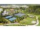 Aerial view of community with tennis courts, playground, and green spaces surrounded by trees at 3312 Francoa Dr, Odessa, FL 33556