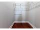 Spacious walk-in closet featuring custom shelving and hardwood floors at 3312 Francoa Dr, Odessa, FL 33556