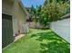 Serene backyard with artificial turf, white vinyl fence, tropical plants, and ample space for outdoor activities at 3516 W Santiago St, Tampa, FL 33629
