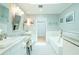 Bright bathroom with double sinks, white cabinets, and soaking tub at 3516 W Santiago St, Tampa, FL 33629
