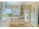 Bright updated kitchen featuring green backsplash, quartz counters, stainless dishwasher and farmhouse sink at 3516 W Santiago St, Tampa, FL 33629