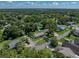 This is an aerial view of a quaint single-story home with mature trees and a fenced yard in a quiet neighborhood at 37153 Mcminn Ave, Dade City, FL 33525