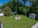 Aerial view of large backyard, showing a fire pit seating area and storage shed at 37153 Mcminn Ave, Dade City, FL 33525