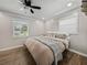 Cozy bedroom features a queen-sized bed with neutral bedding, hardwood floors, and natural light at 37153 Mcminn Ave, Dade City, FL 33525