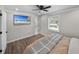 Cozy bedroom featuring a wall-mounted TV, wood-look floors and ample natural light at 37153 Mcminn Ave, Dade City, FL 33525