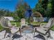 Outdoor fire pit area surrounded by chairs, umbrella and egg chair, ideal for gatherings and relaxation at 37153 Mcminn Ave, Dade City, FL 33525