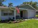 Inviting single-story home with a covered front porch, lush landscaping, and charming curb appeal at 37153 Mcminn Ave, Dade City, FL 33525