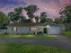 Charming single-story home featuring a well-manicured lawn and freshly painted white exterior with beautiful landscape at 37153 Mcminn Ave, Dade City, FL 33525