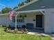 Charming front porch with an American flag, well-maintained landscaping, and a comfortable bench at 37153 Mcminn Ave, Dade City, FL 33525