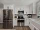 Updated kitchen featuring stainless steel appliances, white cabinets, and stylish tile backsplash at 37153 Mcminn Ave, Dade City, FL 33525