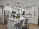 Bright kitchen features white cabinets, stainless steel appliances, and an island with a granite countertop at 37153 Mcminn Ave, Dade City, FL 33525
