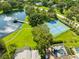 Overhead view showing a tennis court and pond with gazebo in a green, well-maintained community at 3772 Woodridge Pl, Palm Harbor, FL 34684