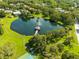 Overhead scene featuring a pond with a fountain and gazebo, surrounded by lush greenery and community features at 3772 Woodridge Pl, Palm Harbor, FL 34684