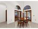 Dining room with dark wood table, chairs, arched windows, and tile flooring at 3772 Woodridge Pl, Palm Harbor, FL 34684